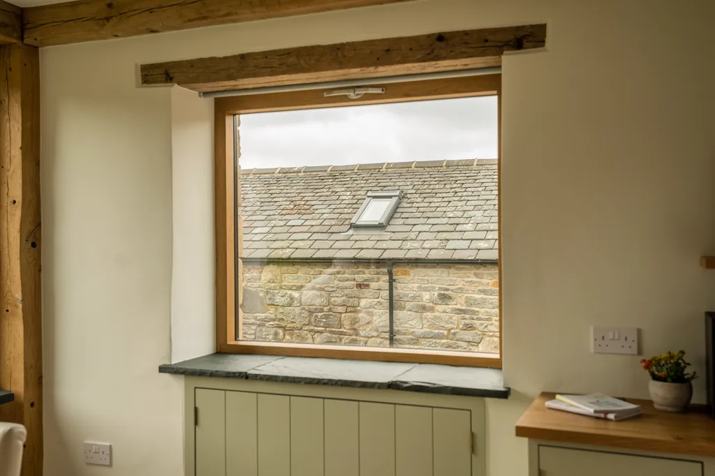 A conservation rooflight in a stone cottage roof, seen from a neighbouring window
