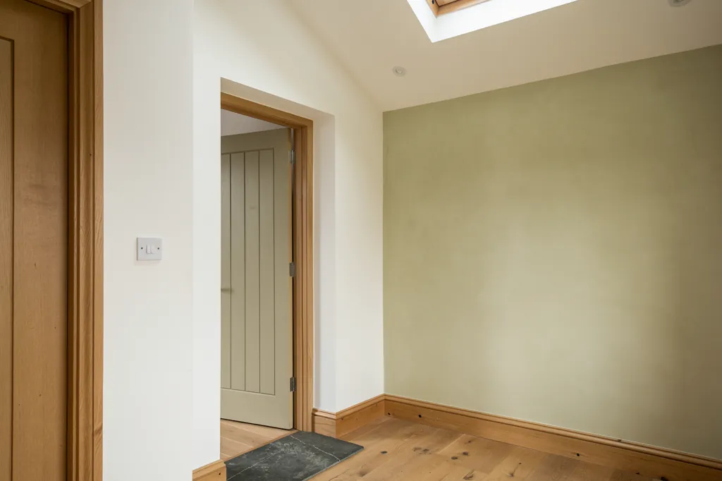 A wall switch beside a doorway under an opening rooflight