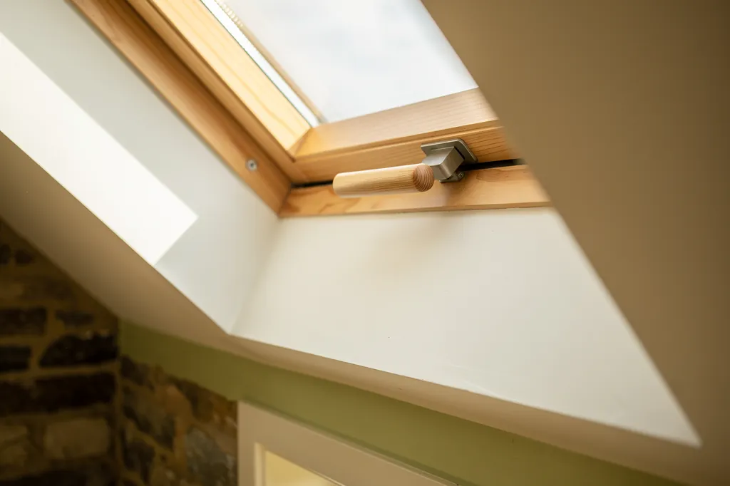 Detail of the top handle of a centre-pivot roof window